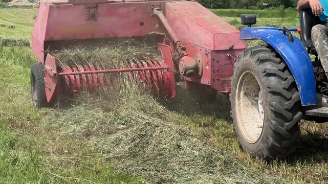 Baling hay with small square baler on a field