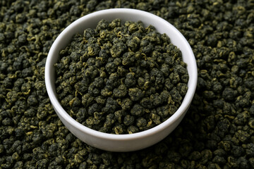 Bowl of Milk Oolong tea, close-up of aromatic Chinese rolled tea leaves