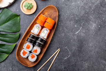 A vibrant assortment of fresh sushi, including nigiri, rolls, and sashimi on grey background top view copy space for text
