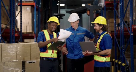 african american male worker discussing shipment checklist with caucasian manager and supervisor in warehouse facility team reviewing cargo stock data for logistic planning and inventory control - Powered by Adobe