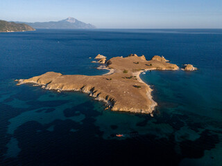 Rocky Island and Boat in Deep Blue Coastal Waters Near Athos, Greece