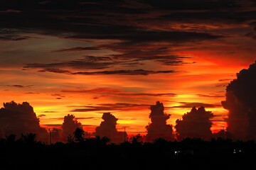 Fiery sunset sky silhouettes dark landscape