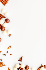 Candy background with chocolate on white table top view frame. Sweets desserts concept. Space for text
