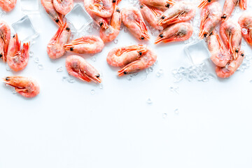 Shrimps - frozen, with ice, at shell - on white backgroud frame copy space