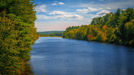 Vibrant lakeshore autumn landscape over Massabesic Lake at NH Audubon Massabesic Center forest in...