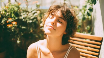 Naklejka premium Portrait of young woman with short curly hair enjoying sunlight outdoors on sunny day.
