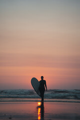 Surfing woman with a surfboard on a beach