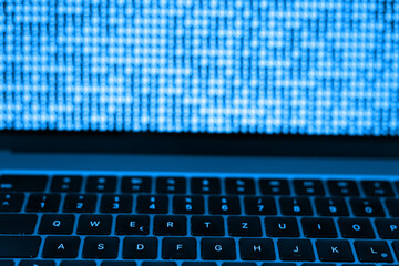 Computer, laptop colored in blue, binary code, system working. Technology, office, computer software, coding.