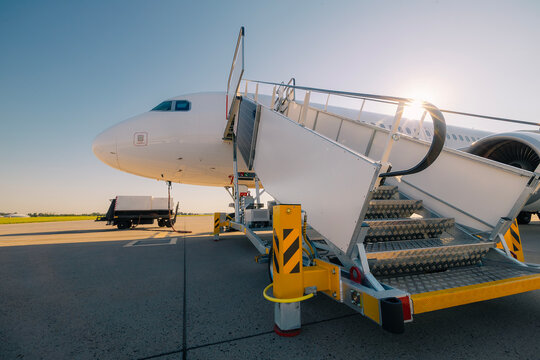 Mobile staircase ready for boarding to airplane at airport on a sunny day.