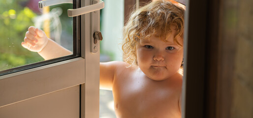 Child Standing at an Open Door During a Warm Afternoon in a Backyard Garden