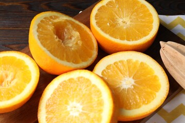 Squeezed oranges and juicer on table, closeup. Making fresh juice