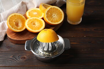 Freshly squeezed orange juice, fruits and juicer on wooden table