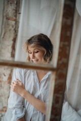 Fototapeta premium sexy woman in white shirt through the window frame.