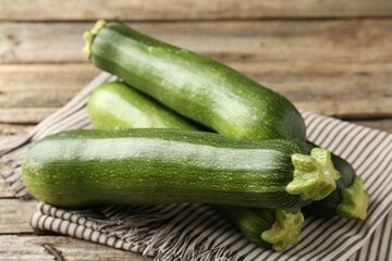 Fresh ripe zucchinis on wooden table, closeup