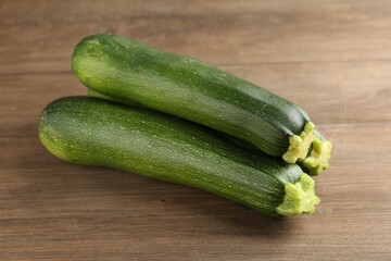 Fresh ripe zucchinis on wooden table, closeup