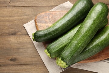 Fresh ripe zucchinis on wooden table, top view. Space for text