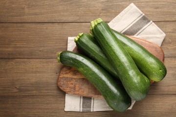 Fresh ripe zucchinis on wooden table, top view. Space for text