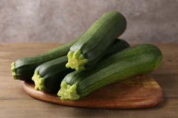 Fresh ripe zucchinis on wooden table, closeup
