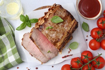 Delicious baked beef meat, tomatoes, spices and water with lime on light table, flat lay