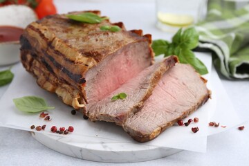 Delicious baked beef meat and spices on light table, closeup