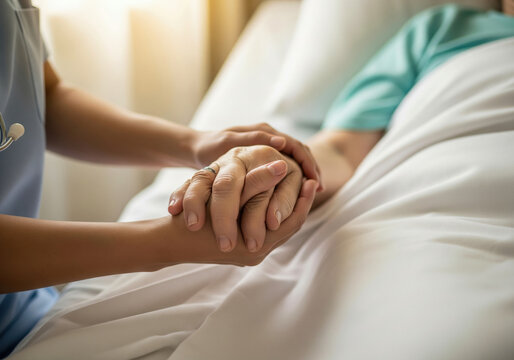 Hospice nurse's hands holding the hand of a dying patient providing comfort in their final moments