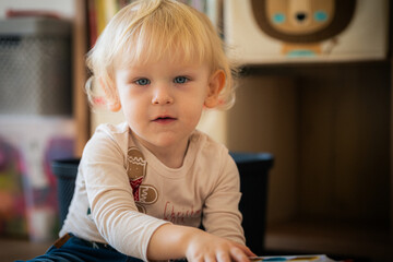 Blond little boy in Christmas shirt looking directly at camera during holiday season