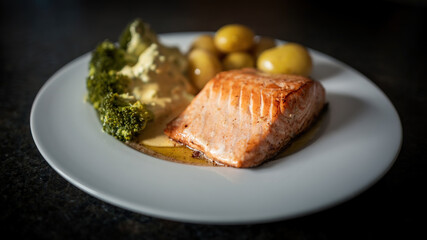 ready to eat - grilled salmon, broccoli and potatoes with butter and hollandaise sauce