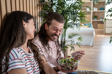 Obraz premium Happy couple enjoying healthy salad at home