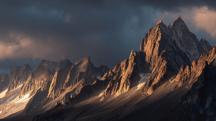 A dramatic landscape featuring jagged mountain peaks illuminated by sunlight under a cloudy sky