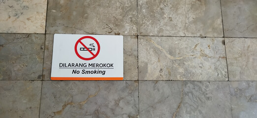 No smoking sign. A non-smoking area on a stone wall. The area is not for smoking.