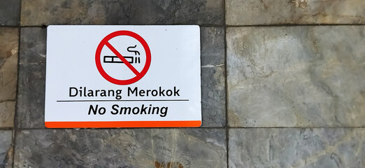 No smoking sign. A non-smoking area on a stone wall. The area is not for smoking.