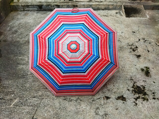 colorful patterned umbrellas in the yard after rain. rainbow umbrella. natural background. colorful umbrella, symbol of rainy weather season. copy space. banner