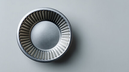 Top view of single clean metallic muffin tin for baking. empty round kitchenware mold sits on plain background, ready for homemade recipe or culinary creation