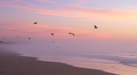 Naklejka premium Seagulls flying over the ocean at sunset.