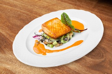 Fried tasty fish steak with cooked vegetables