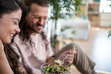 Fototapeta premium Happy couple enjoying fresh salad at home