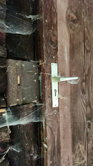 uninhabited abandoned house. door handle in a cobweb. loneliness and abandonment