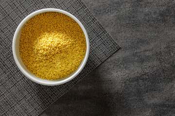 raw millet groats in bowl, top view