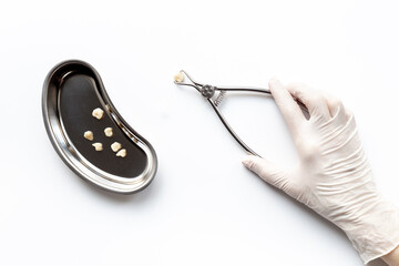 Dentist hand in white medical glove is holding dental equipment tools for teeth care on white background. Professional Dentist desktop, top view