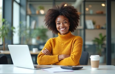 Smiling African American woman in yellow sweater studies business management. Uses laptop, calculator in modern office. Female graduate plans creative business ideas. Represents education,