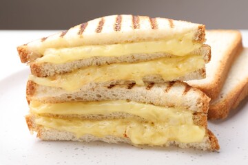 Tasty sandwiches with melted cheese on table, closeup