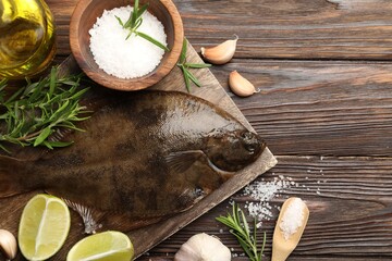 Fresh flounder fish, salt and products on wooden table, flat lay. Raw seafood