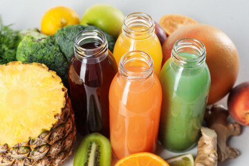 Tasty juices in glass bottles and ingredients on table, closeup