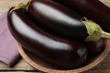 Many ripe eggplants on wooden table, closeup
