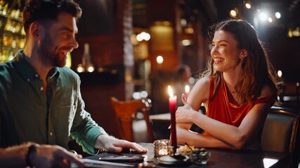 Two friends looking menu in dark cafe interior closeup. Happy couple discussing - Powered by Adobe