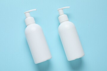 Cosmetic products on light blue background, flat lay. Mockup for design