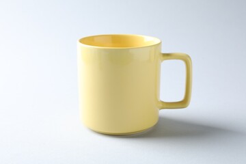 Yellow mug on light background. Mockup for design