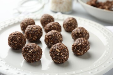 Tasty chocolate candies with nuts on white table, closeup