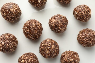 Tasty chocolate candies with nuts on white table, flat lay