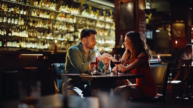 Loving couple bonding evening date in modern dark restaurant. Affectionate man